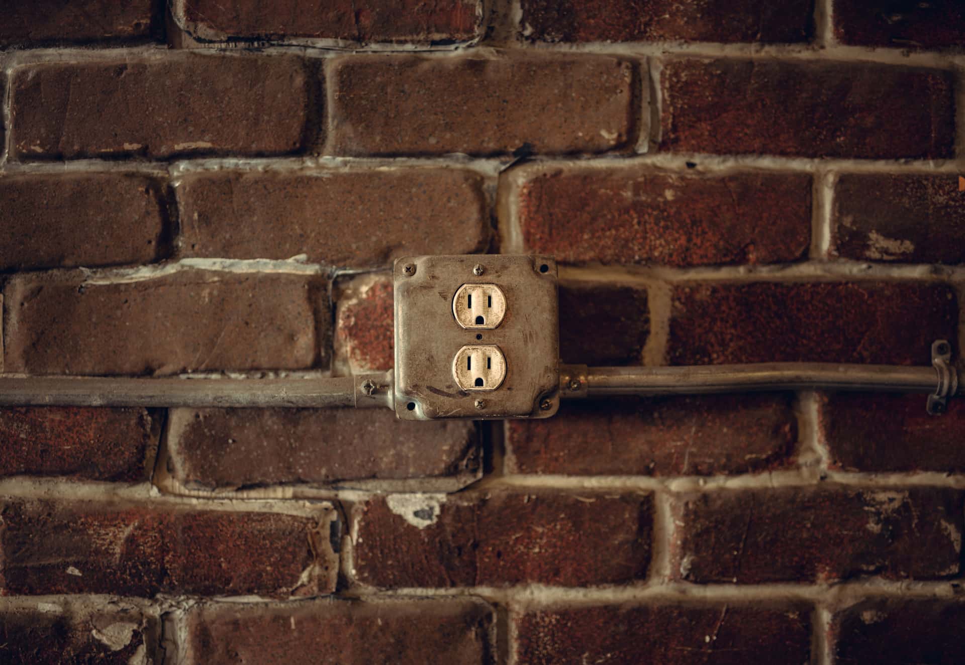 A weatherproof outdoor electrical socket mounted on an exterior wall.