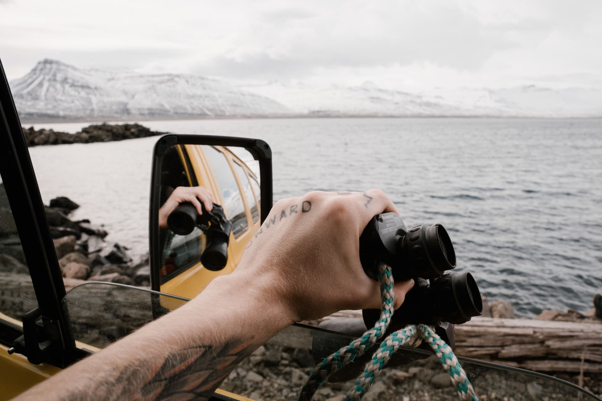 A pair of binoculars held up against a snowy landscape.