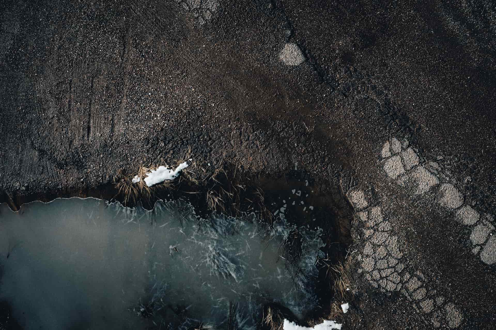 A frozen puddle with cracks radiating across the ice on a winter morning.