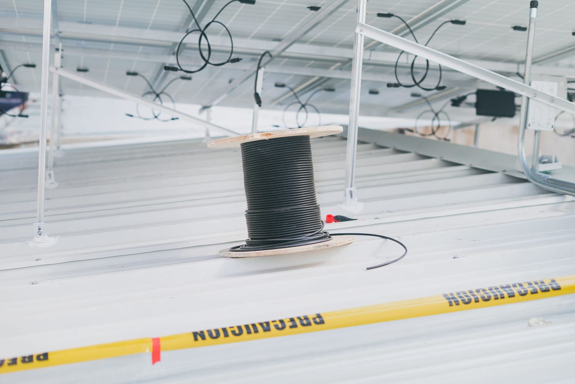 A coiled outdoor electrical extension cable resting on a wooden surface.