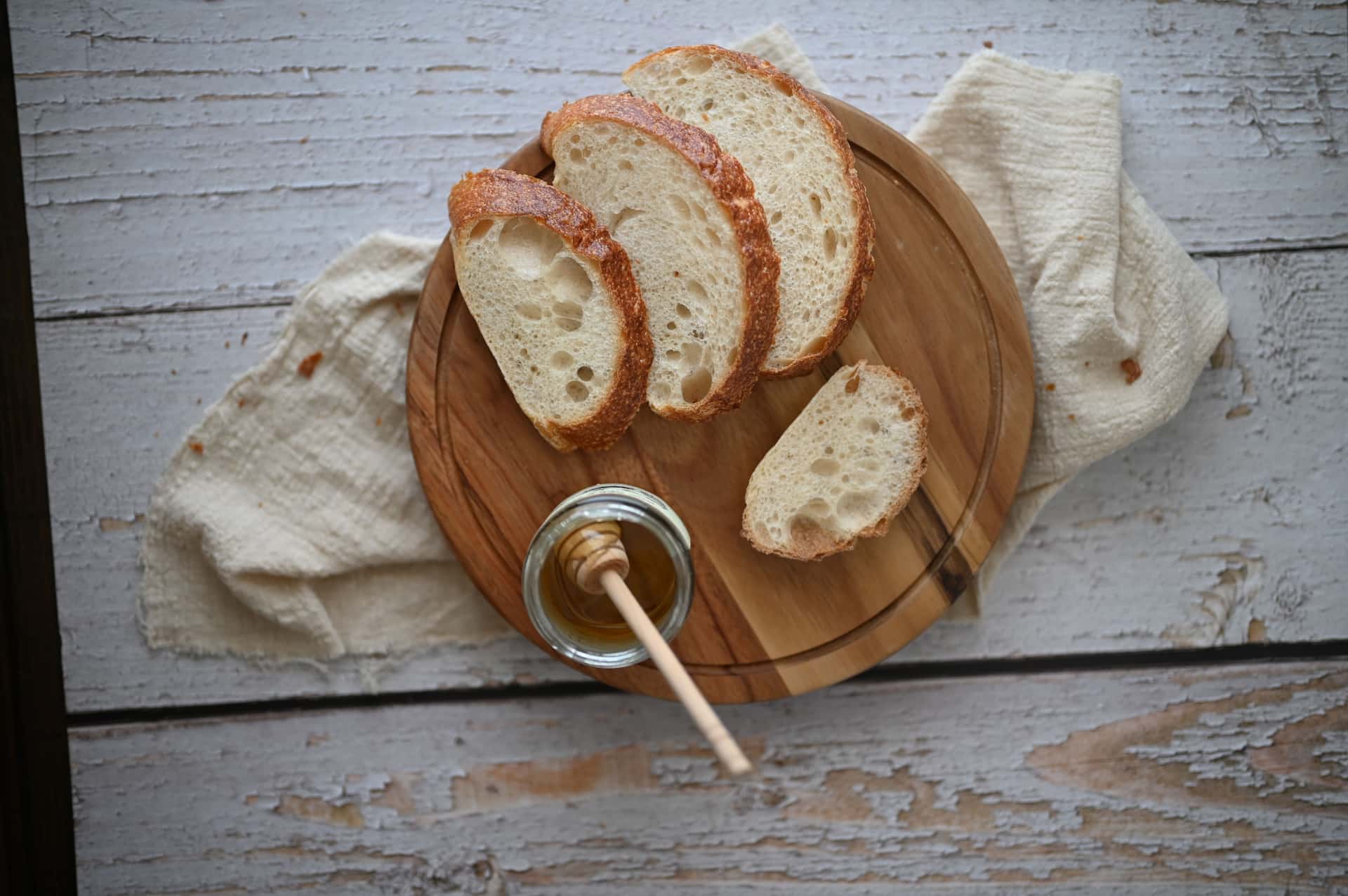 Slices of stale white bread on a wooden board.